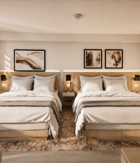 Two neatly made queen beds occupy a modern hotel room. Sunlight streams through a window, highlighting the abstract artwork above wooden headboards and a plush rug.