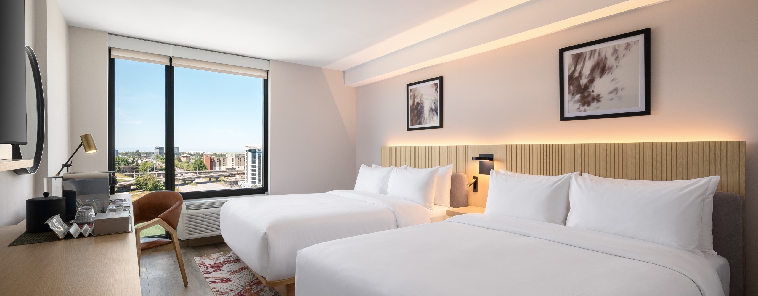 Two queen beds with a city view out the window