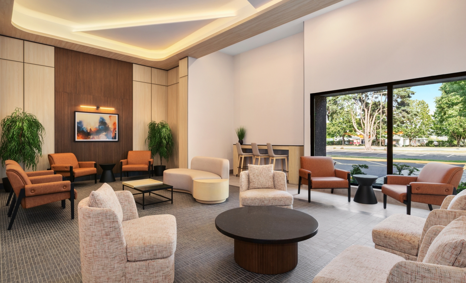 Modern hotel lobby with tan upholstered chairs, round coffee tables, and wood paneled walls near a large windowed wall.